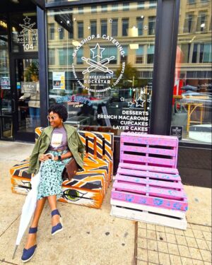 Black woman sitting on a mural chair in Asbury park